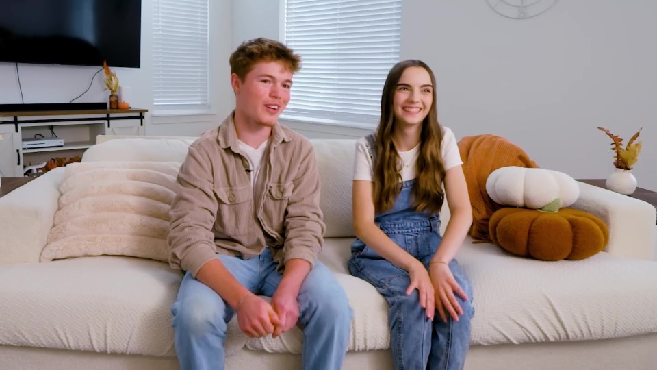 a man and a woman sit on a white couch