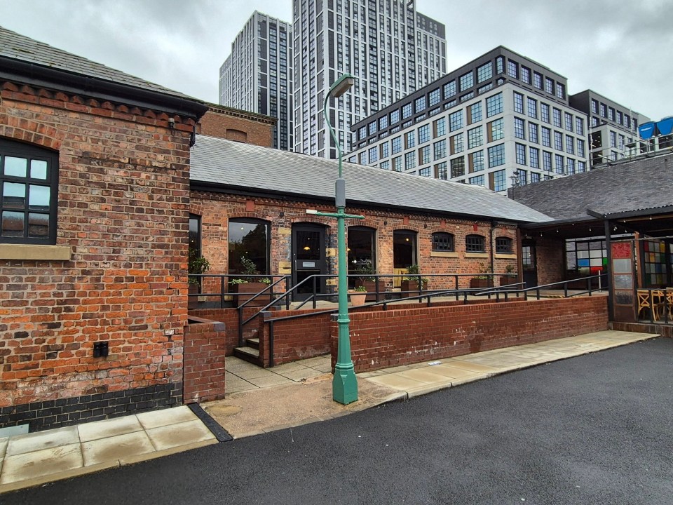 a brick building with a green pole in front of it