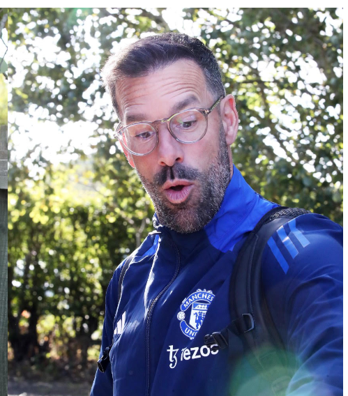 a man wearing a blue manchester united jacket