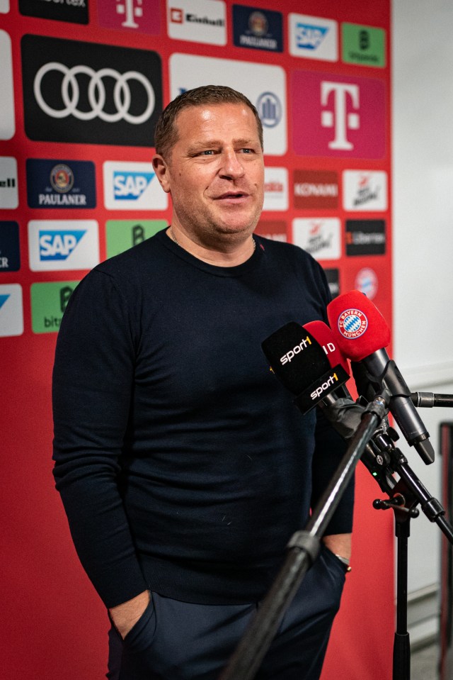 a man wearing a black sweater stands in front of a microphone with the word sport on it