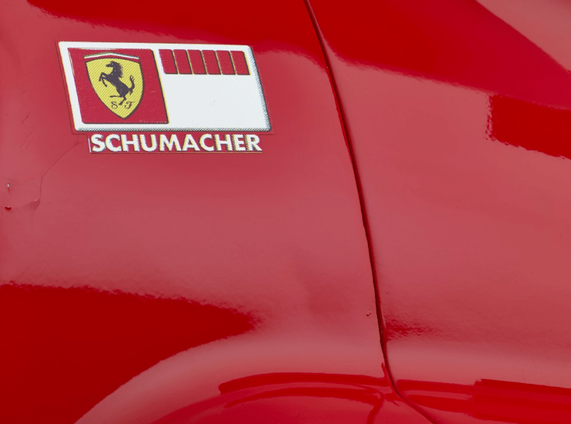 a red car has a sticker on the side that says schumacher