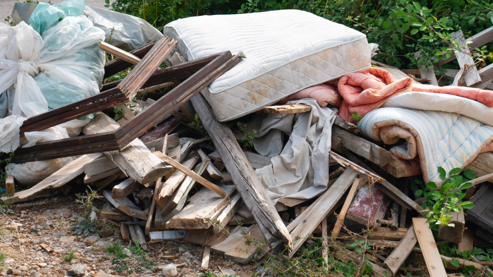 a pile of garbage with a mattress on top