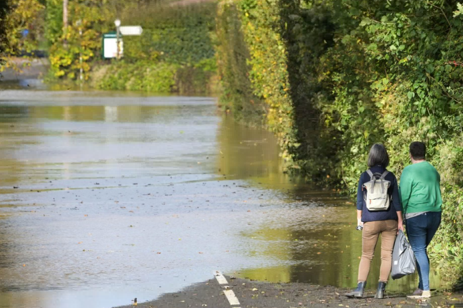 two people standing in a flooded area with a sign that says ' a ' on it