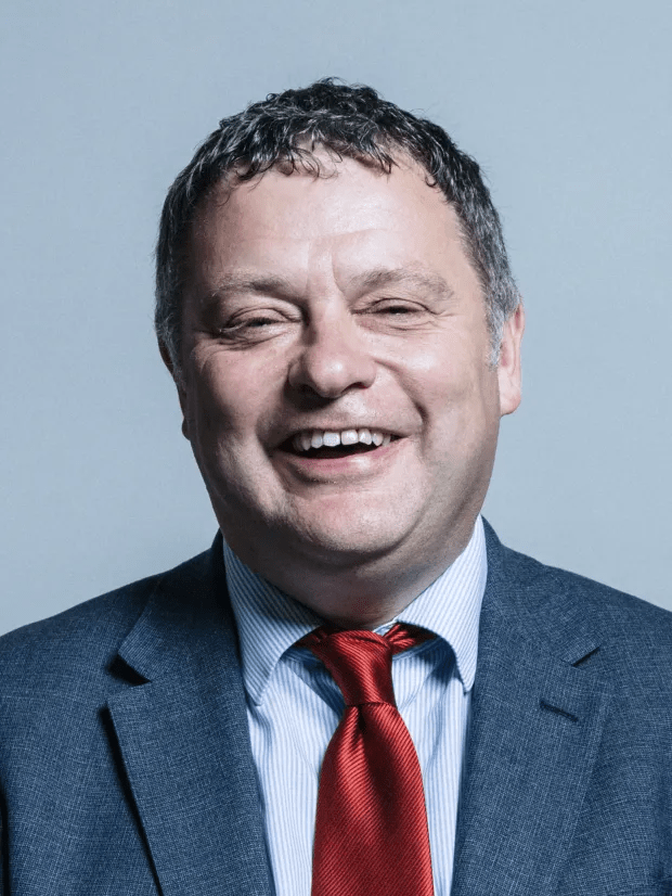 a man in a suit and tie is smiling for the camera