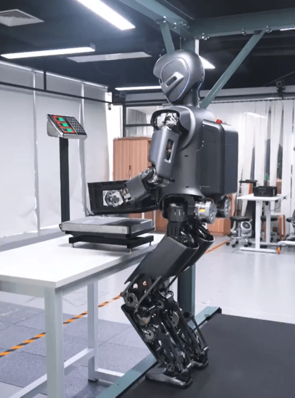 a robot is standing next to a table with a scale on it