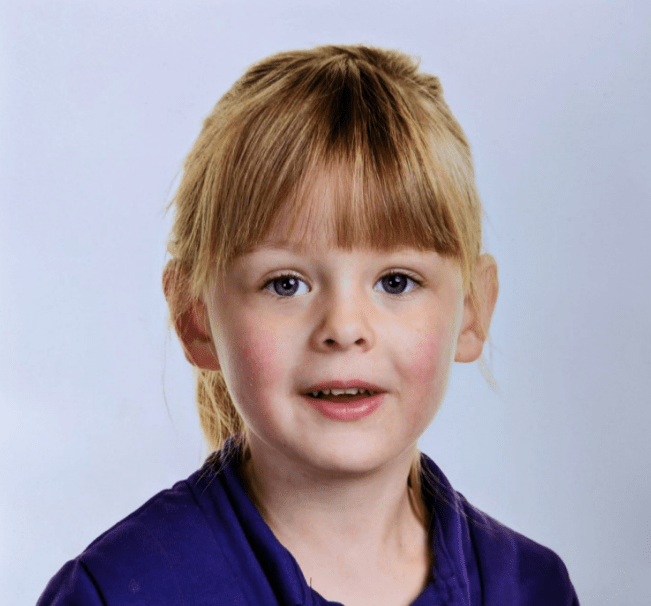 a little girl with blonde hair and blue eyes is wearing a purple shirt