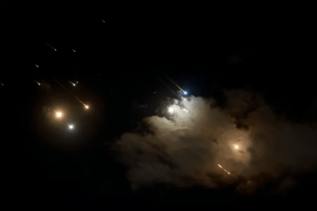 a fireworks display in the night sky with smoke coming out of it