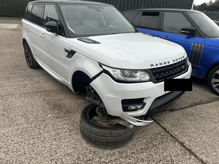 a white range rover with a broken tire