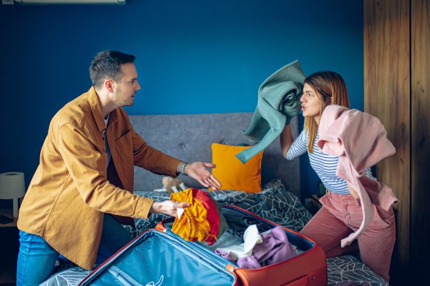 a man and a woman are fighting over a suitcase