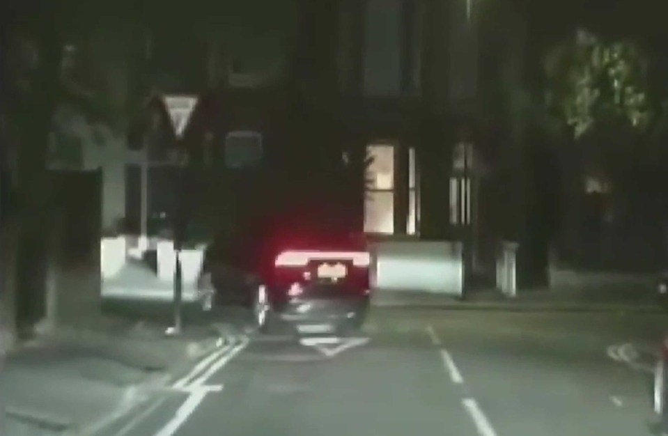 a car is driving down a street at night .