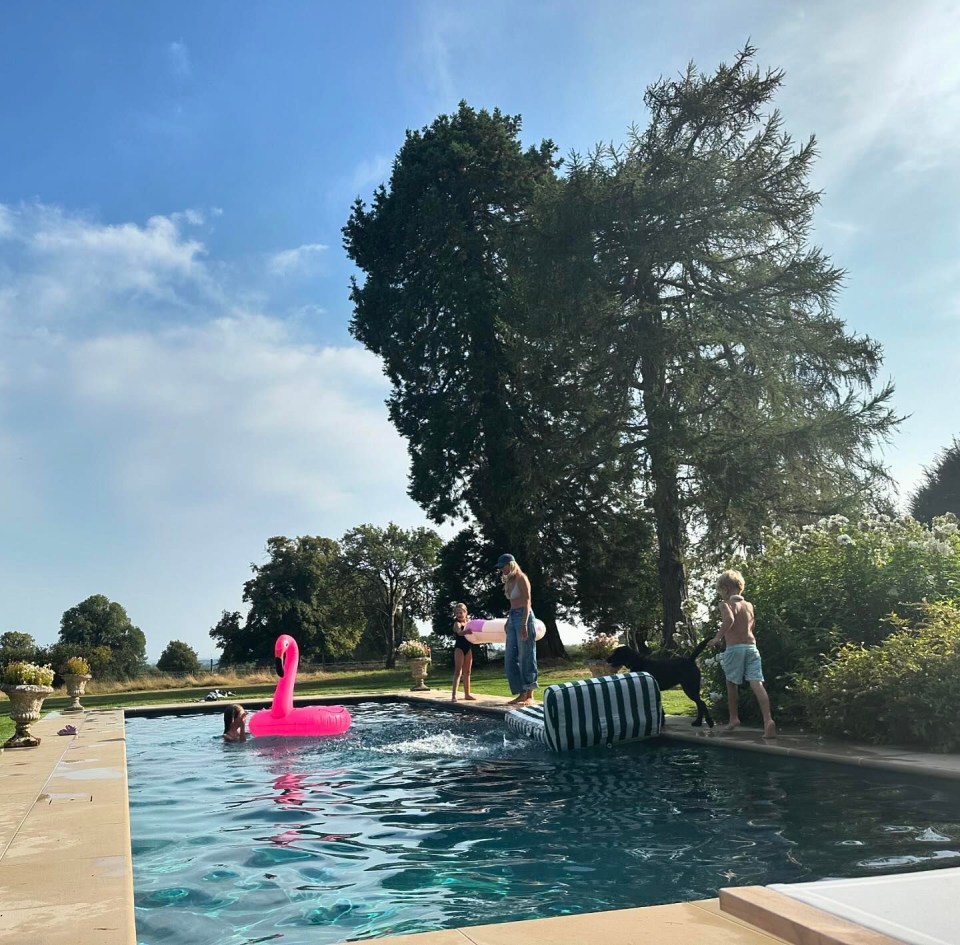 a group of people are playing in a pool with a pink flamingo float