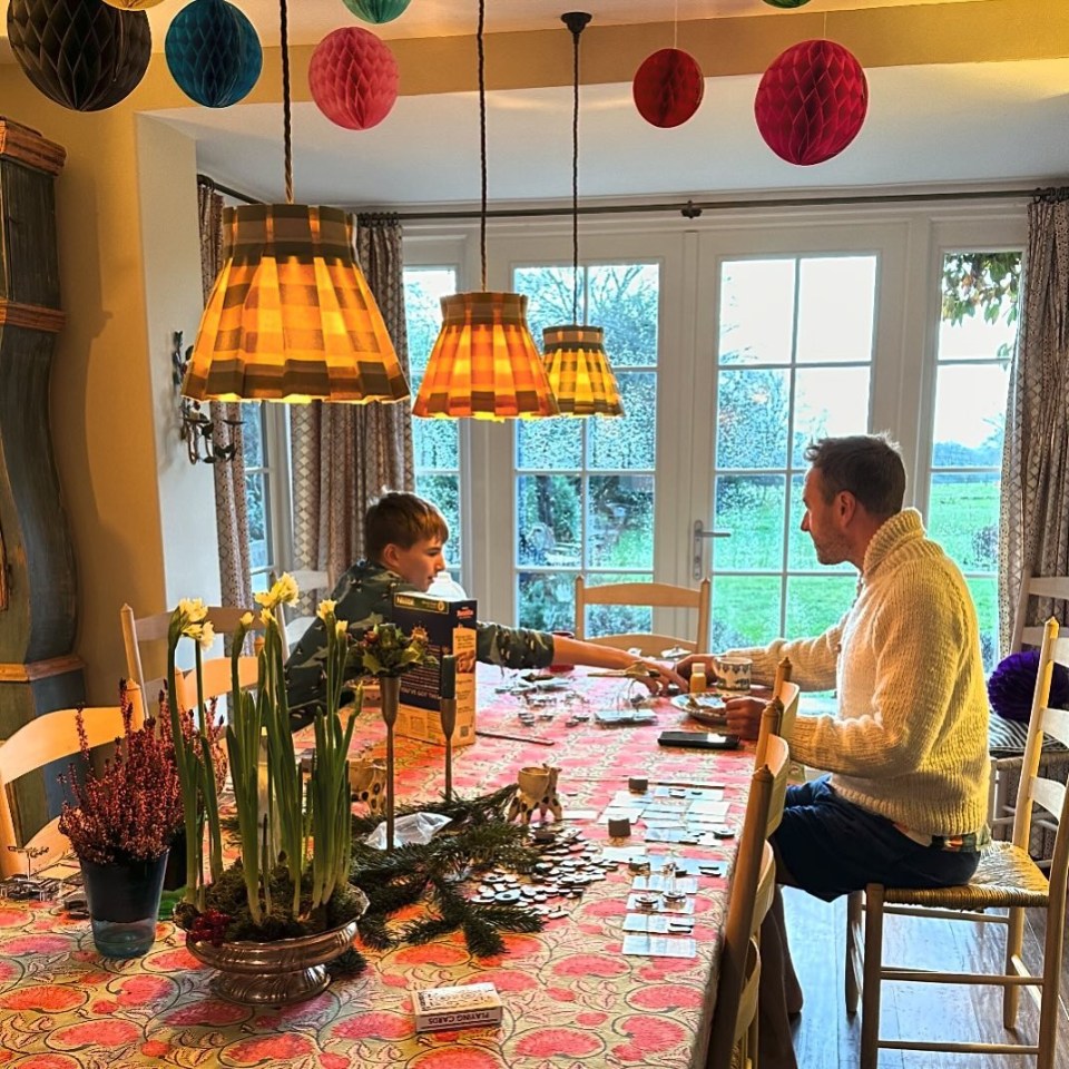 a man and a boy sit at a table playing a board game