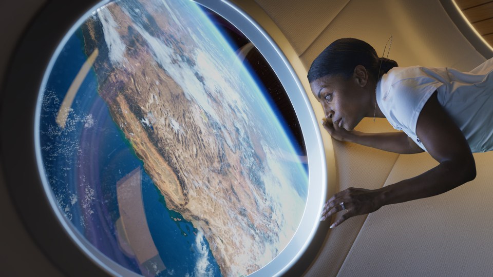 a woman looks out a window at the earth