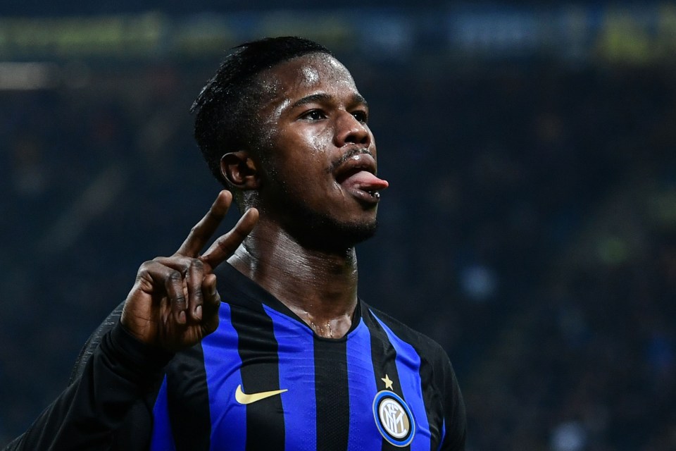 a soccer player wearing a black and blue nike jersey sticks his tongue out