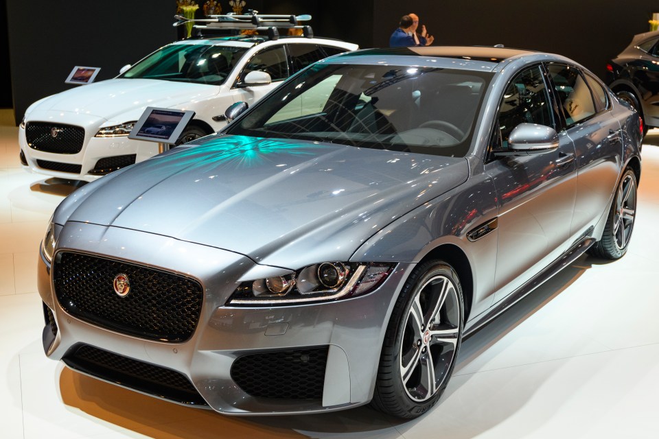 two jaguar cars are on display at a car show