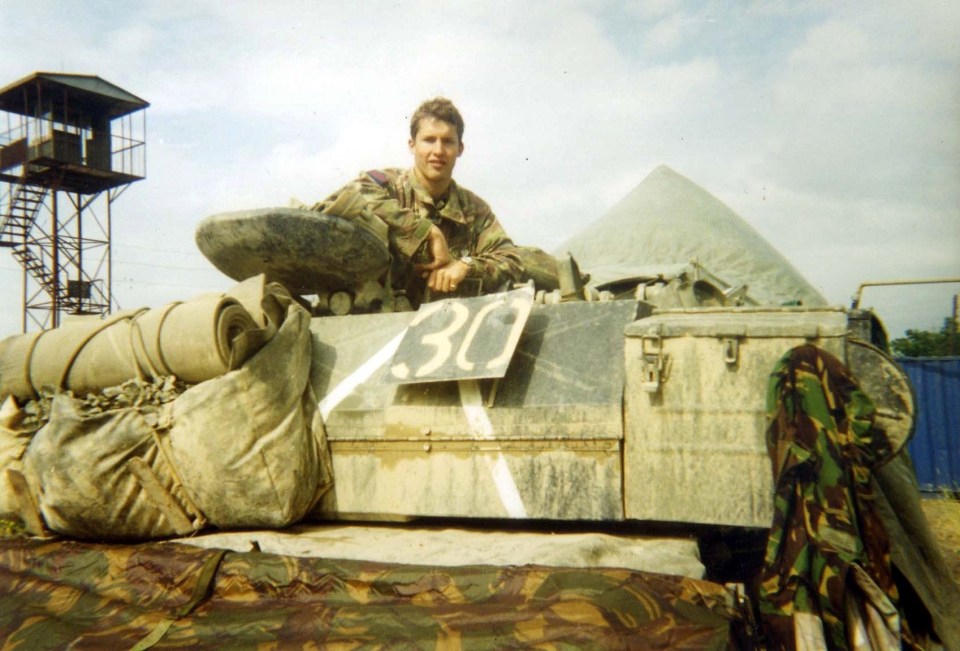 a man sits on top of a tank with the number 30 on it