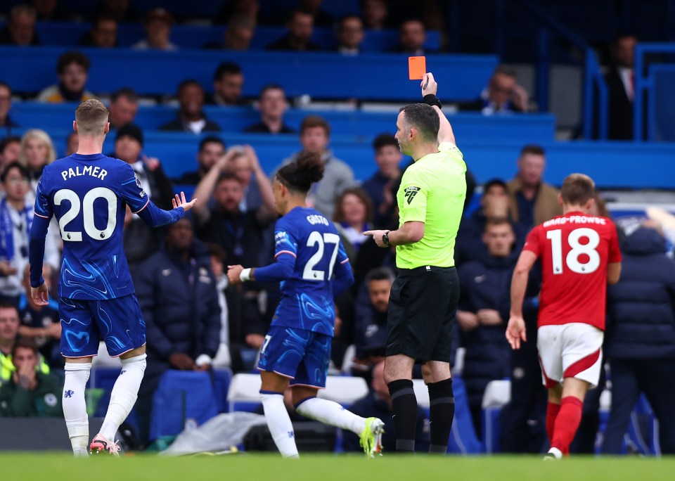 soccer player number 20 palmer is shown a red card by the referee