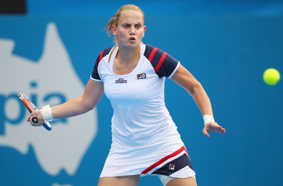 a woman in a fila shirt is playing tennis