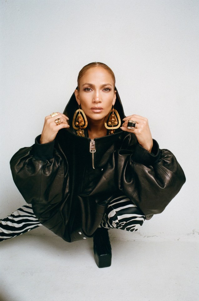 a woman wearing a black leather jacket and zebra print pants