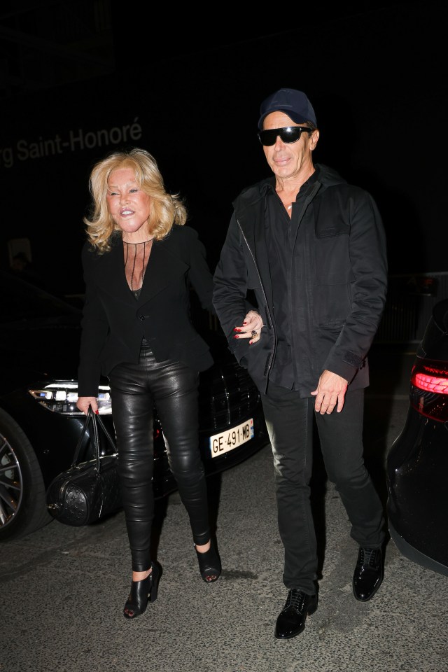 a man and a woman are walking in front of a sign that says saint honore