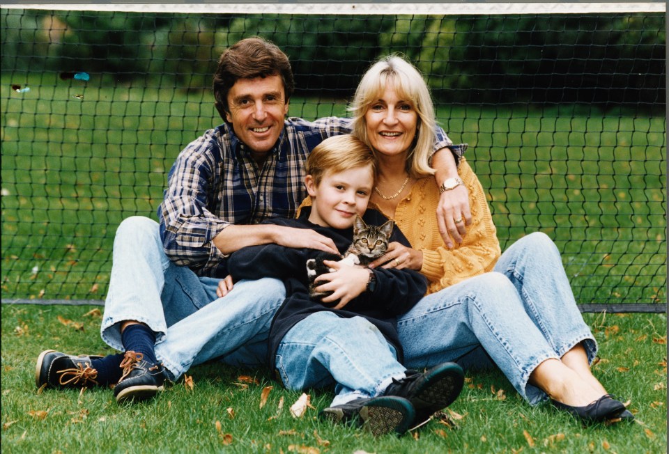 a family posing for a picture in front of a tennis net