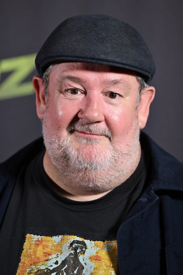 a man with a beard wearing a hat and a black shirt