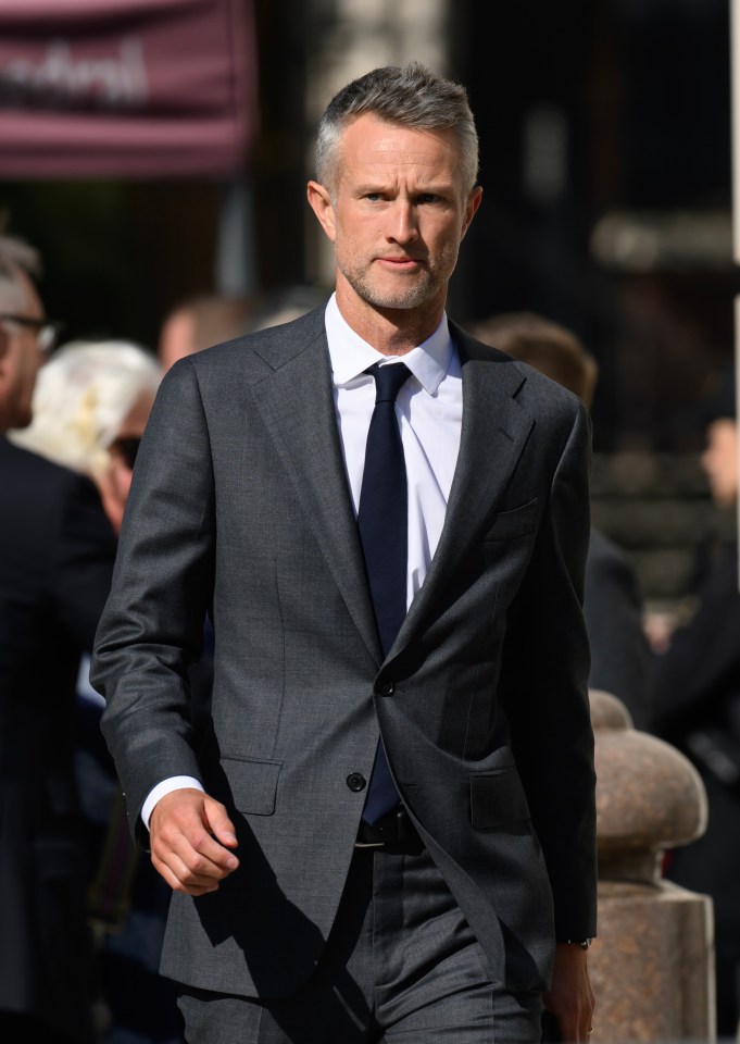 a man in a suit and tie walks down a street