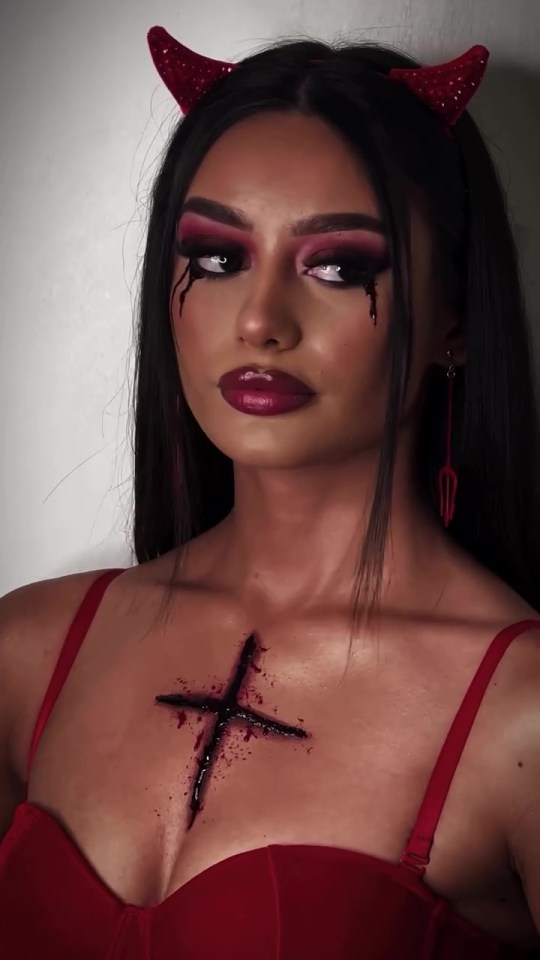 a woman with devil horns and a cross on her chest