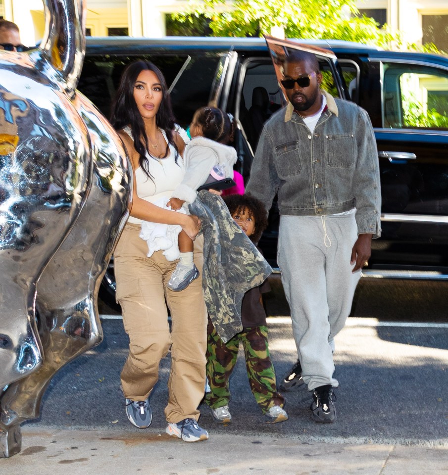 kanye west and kim kardashian are walking with their children