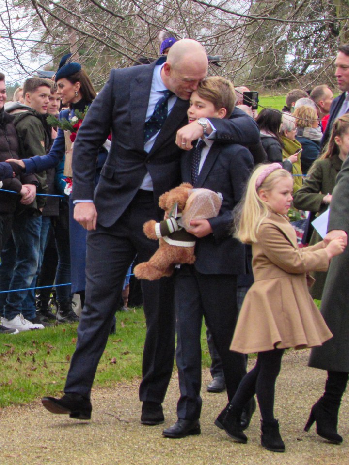 a man in a suit holds a teddy bear in his arms