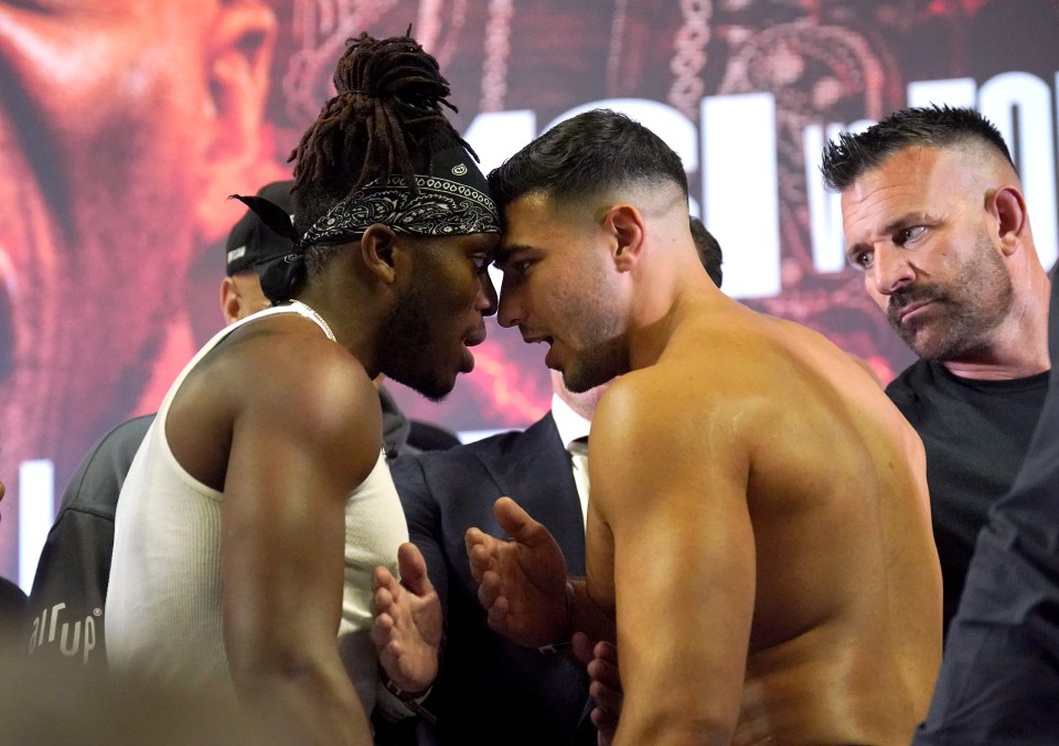 a man with a bandana on his head stands next to another man