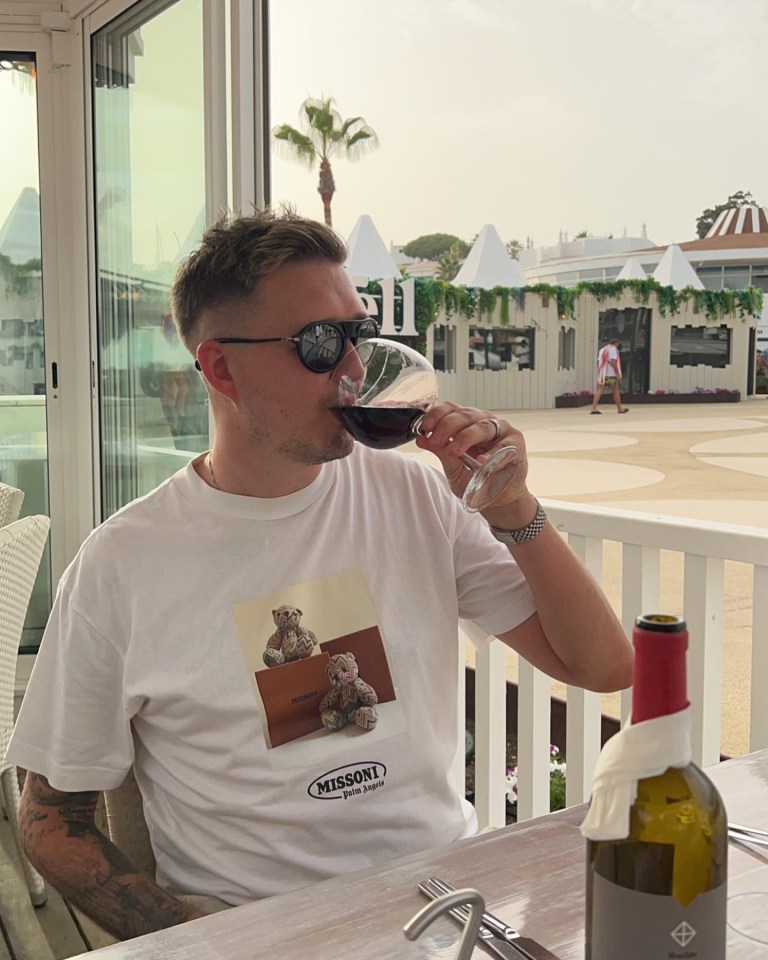 a man wearing a missoni shirt is drinking wine