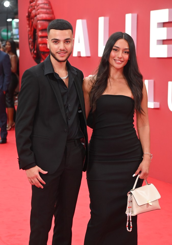 a man and a woman pose for a picture on a red carpet