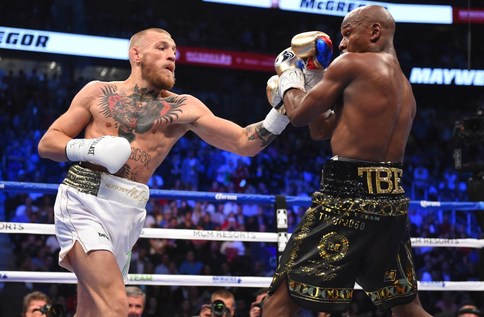 two boxers in a ring with one wearing a belt that says tbe