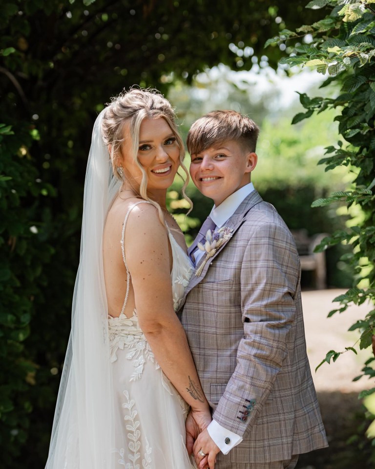 a bride and groom hold hands and smile for a picture