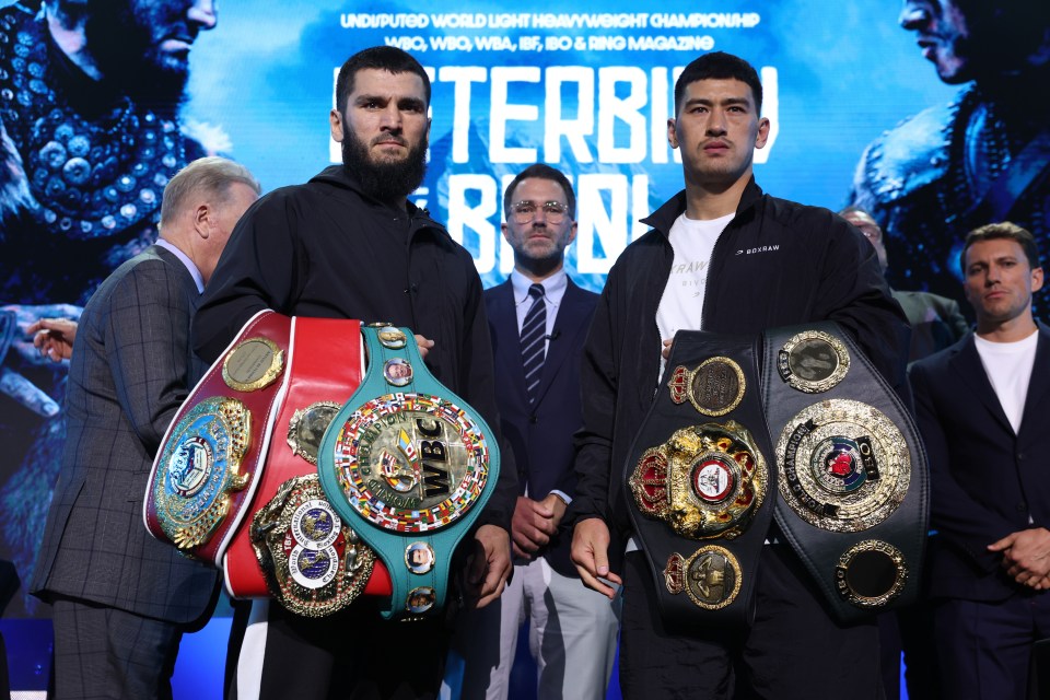 two boxers standing next to each other in front of a sign that says terbii