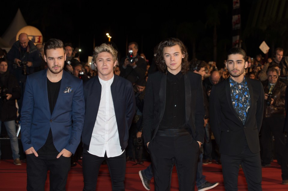 a group of men standing next to each other on a red carpet