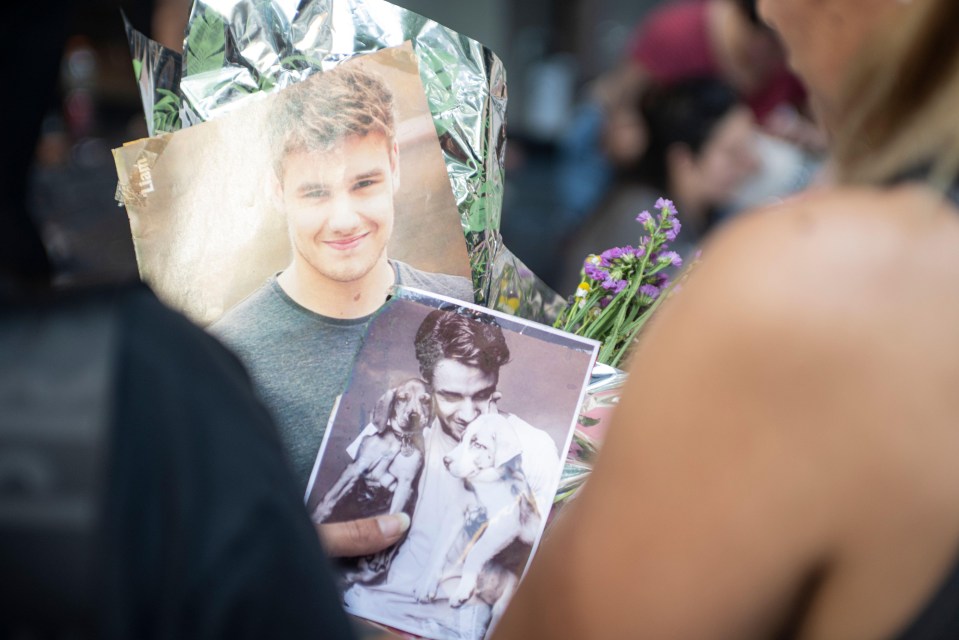 a woman holding a picture of a man and a dog with the word love on it