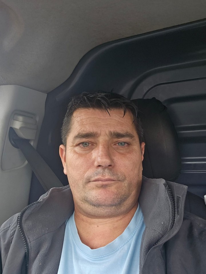 a man wearing a blue shirt and a grey jacket is sitting in a car