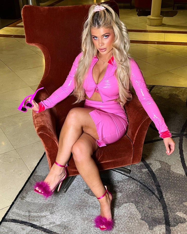 a woman in a pink dress is sitting in a chair