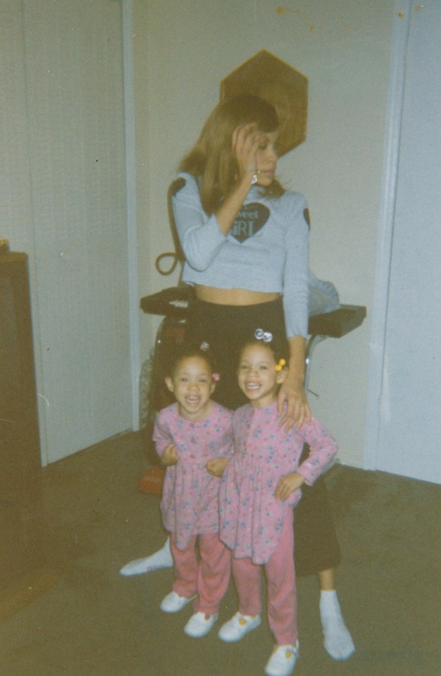 a woman holds two little girls in her arms and one of the girls has a shirt on that says " i am a girl "