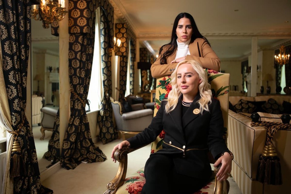 two women are posing for a picture in a living room