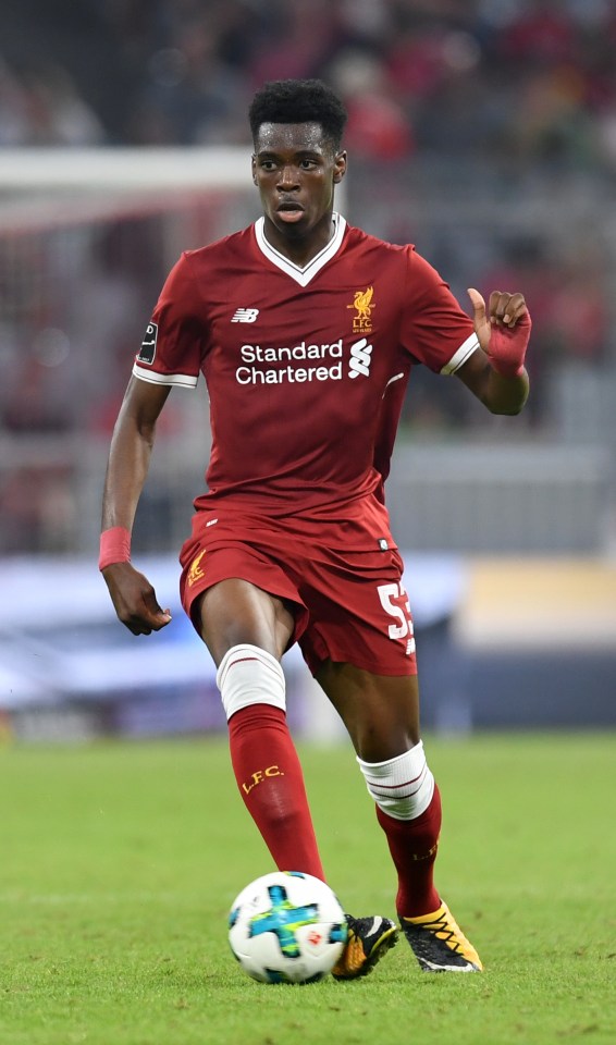 soccer player wearing a red jersey that says standard chartered