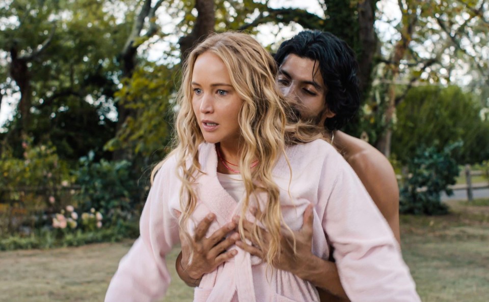 a woman in a pink robe is being held by a shirtless man