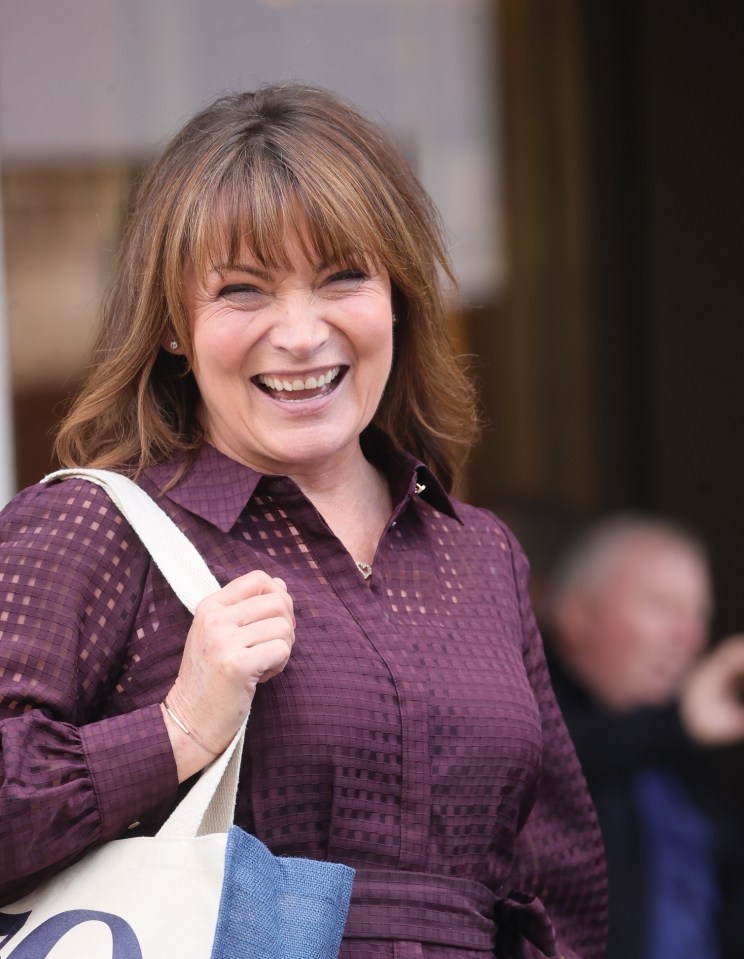 a woman in a purple shirt is smiling while holding a tote bag