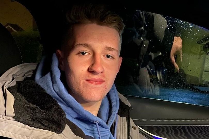 a young man wearing a blue hoodie is sitting in the back seat of a car .