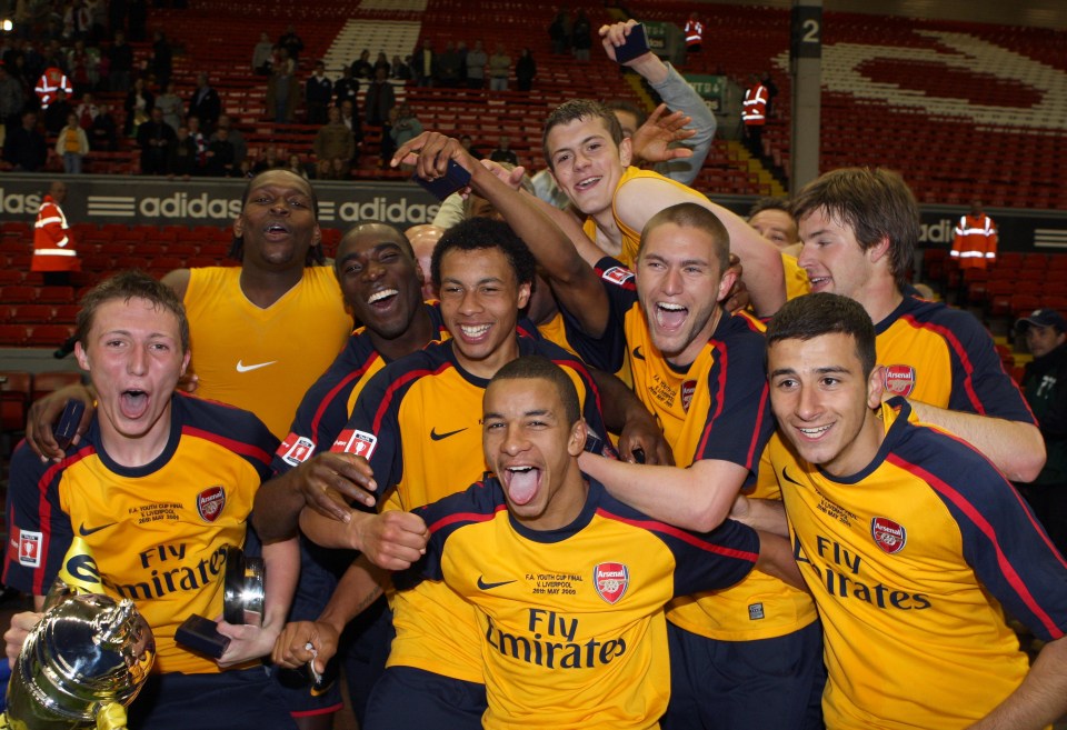 a group of soccer players wearing fly emirates jerseys