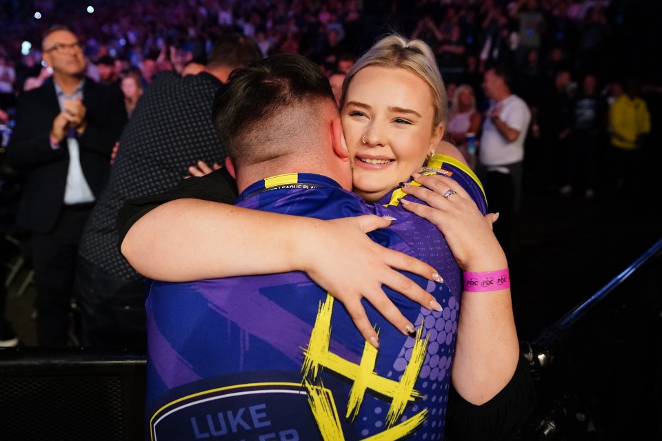 a woman hugging a man wearing a shirt that says luke