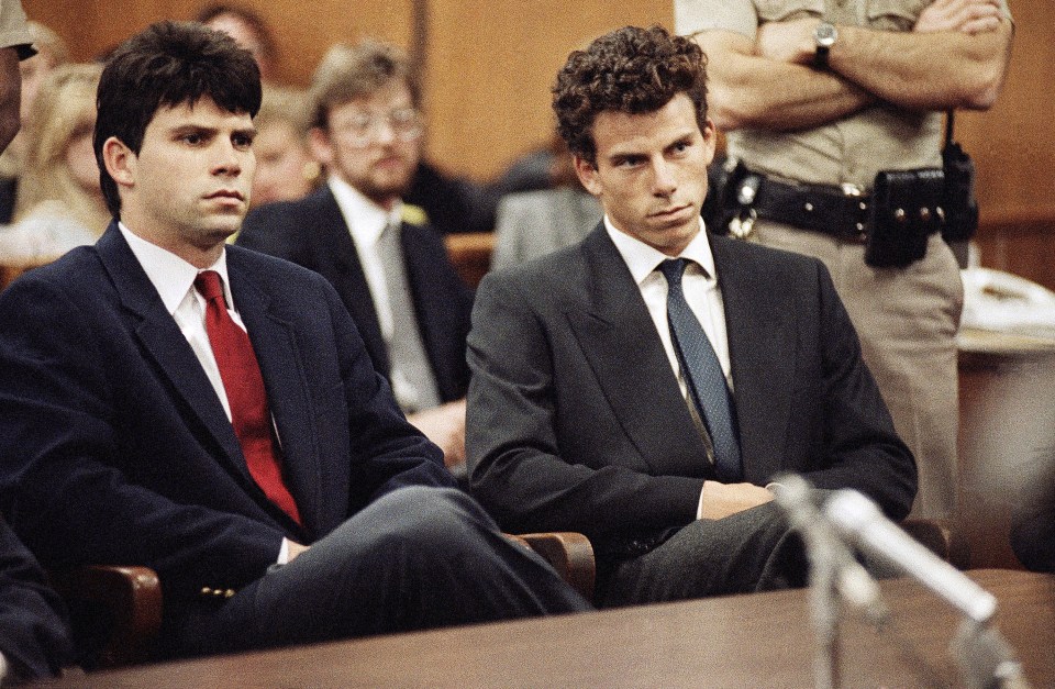 two men in suits and ties sit in a courtroom