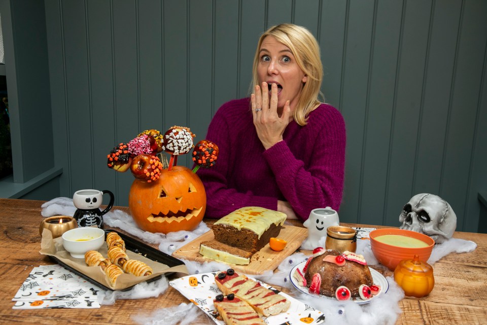 a woman is sitting at a table with halloween treats